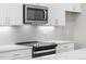 Close-up of a modern kitchen with stainless steel appliances and white subway tile backsplash at 9468 W 58Th Ln # C, Arvada, CO 80002