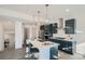 Stylish kitchen features a central island with seating, pendant lighting, stainless steel appliances, and sleek countertops at 15336 W 68Th Loop, Arvada, CO 80007