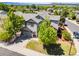 Aerial view of a gray two-story home with a well-maintained lawn, mature trees, and mountain views at 4467 Trailside Ln, Castle Rock, CO 80109