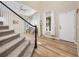 Elegant foyer with hardwood floors, a staircase with a black railing, and ample natural light streaming through large windows at 4467 Trailside Ln, Castle Rock, CO 80109