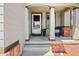 Inviting front porch with brick accents, a comfortable chair, and a welcoming entrance, perfect for relaxing evenings at 4467 Trailside Ln, Castle Rock, CO 80109