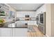 Updated kitchen featuring white cabinets, stainless steel appliances, a black countertop, and a window at 4467 Trailside Ln, Castle Rock, CO 80109