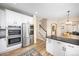 Open kitchen layout with modern appliances, white cabinets, and a view into the dining area at 4467 Trailside Ln, Castle Rock, CO 80109