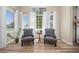 Cozy living room with hardwood floors, comfortable armchairs, and large windows dressed with elegant curtains, creating an inviting space at 4467 Trailside Ln, Castle Rock, CO 80109