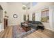 Bright living room features soaring ceilings, many windows, brick fireplace, and beautiful area rug at 4467 Trailside Ln, Castle Rock, CO 80109