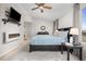 Bright main bedroom with a king bed, ceiling fan, and modern electric fireplace at 4467 Trailside Ln, Castle Rock, CO 80109