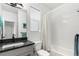 Modern bathroom features a black granite vanity, neutral tiled shower, and contemporary fixtures at 6396 Nelson Ct, Arvada, CO 80004