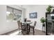 Cozy dining area with a round table, stylish chairs, and a view from a large window at 6396 Nelson Ct, Arvada, CO 80004