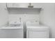 Practical laundry area with white front-load washer and dryer, complemented by a shelf above at 6396 Nelson Ct, Arvada, CO 80004