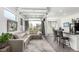 Open-concept living space with sectional sofa, glass garage door, and counter seating at a black island at 6396 Nelson Ct, Arvada, CO 80004