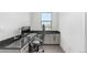 Modern home office with granite desk, gray cabinets, and natural light from a window at 6396 Nelson Ct, Arvada, CO 80004