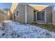 Tan siding home with small backyard partially covered in snow at 11860 Harrison St, Thornton, CO 80233