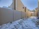 Backyard with a tall privacy fence and partially snow covered ground at 11860 Harrison St, Thornton, CO 80233