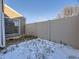 Backyard with a privacy fence and a partially snow covered ground at 11860 Harrison St, Thornton, CO 80233