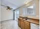 Kitchen with wood cabinets, double sink, and access to a dining area at 11860 Harrison St, Thornton, CO 80233