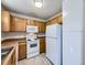 Light wood kitchen cabinets, white appliances and a double sink at 11860 Harrison St, Thornton, CO 80233