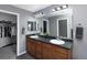 Bathroom with double sinks, wooden cabinets, and a large mirror, leading to a walk-in closet at 338 Mt Wilson St, Brighton, CO 80601