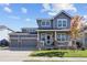 Charming two-story home featuring a covered front porch and a three-car garage at 338 Mt Wilson St, Brighton, CO 80601