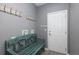 Practical mud room with a teal bench, hooks, and a white door at 338 Mt Wilson St, Brighton, CO 80601