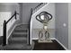 Close up of staircase with gray carpet and gray wall with decorative mirror and table at 338 Mt Wilson St, Brighton, CO 80601