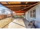 Covered patio area perfect for outdoor relaxation with a view of the multi-tiered backyard and a glimpse of a wooden fence at 17665 E Temple Dr, Aurora, CO 80015