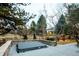 Backyard area features a partially covered hot tub, privacy fence and various trees at 7743 S Jersey Way, Centennial, CO 80112