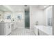 Bright bathroom showcasing a glass shower, soaking tub, and white cabinetry with geometric tile floor at 7743 S Jersey Way, Centennial, CO 80112