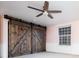 Bedroom with a rustic barn door, light pink walls and a ceiling fan at 7743 S Jersey Way, Centennial, CO 80112