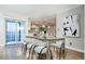 Sunlit dining room with glass table and chairs, connected to a modern kitchen and a sliding glass door at 7743 S Jersey Way, Centennial, CO 80112