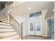 Bright entryway featuring double doors and a staircase with iron railings at 7743 S Jersey Way, Centennial, CO 80112