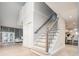 Bright foyer with hardwood floors, open staircase, and views into the living room and kitchen at 7743 S Jersey Way, Centennial, CO 80112