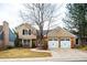 Inviting two-story home with a manicured lawn, two-car garage, and a beautiful tree in the front yard at 7743 S Jersey Way, Centennial, CO 80112