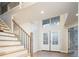 Bright foyer featuring wood stairs, modern doors, and large windows at 7743 S Jersey Way, Centennial, CO 80112