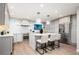 Modern kitchen with white cabinets, stainless steel appliances, quartz countertops and island with seating at 7743 S Jersey Way, Centennial, CO 80112