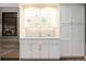 Kitchen features custom cabinets, stainless steel refrigerator, tile backsplash and a wine cooler at 7743 S Jersey Way, Centennial, CO 80112