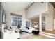 Open-concept living room with soaring ceilings, a fireplace, and views into the dining and kitchen areas at 7743 S Jersey Way, Centennial, CO 80112