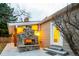 Cozy outdoor patio featuring a stone fireplace, wooden beam supports, and sconce lighting at 7743 S Jersey Way, Centennial, CO 80112