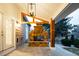 Inviting outdoor patio with a stone fireplace, wood beams and a hanging light fixture at 7743 S Jersey Way, Centennial, CO 80112