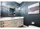 Stylish powder room with unique lighting, vessel sink, and decorative mirror at 7743 S Jersey Way, Centennial, CO 80112