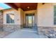 Inviting covered entryway with stonework and glass door at 449 Meadow View Pkwy, Erie, CO 80516