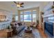 Cozy living room featuring fireplace, large windows, and hardwood floors at 449 Meadow View Pkwy, Erie, CO 80516