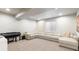Basement area with a comfy sectional, piano and cozy lighting, perfect for relaxation and entertainment at 507 Red Thistle Dr, Highlands Ranch, CO 80126