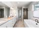 Bright bathroom featuring a soaking tub, a large vanity, and a walk-in shower at 507 Red Thistle Dr, Highlands Ranch, CO 80126