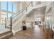 Bright foyer with hardwood floors, soaring ceilings, staircase with white railings, and large windows at 507 Red Thistle Dr, Highlands Ranch, CO 80126