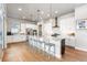 Stylish kitchen with white cabinets, stainless steel appliances, large island with seating, and hardwood floors at 507 Red Thistle Dr, Highlands Ranch, CO 80126