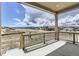 Covered porch with wood railing overlooking a vacant lot with blue sky at 483 Agoseris Way, Castle Rock, CO 80104