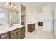 A luxurious primary bath with dual sinks, stone countertops, a walk-in shower and marble tiling at 483 Agoseris Way, Castle Rock, CO 80104