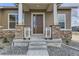 Welcoming front porch with stone pillar accents and a modern front door at 483 Agoseris Way, Castle Rock, CO 80104