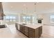 Open concept kitchen features a large island, stainless steel appliances, and adjoins a living space with a fireplace at 483 Agoseris Way, Castle Rock, CO 80104
