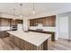 Modern kitchen featuring a large island, stainless appliances, and dark wood cabinets at 483 Agoseris Way, Castle Rock, CO 80104